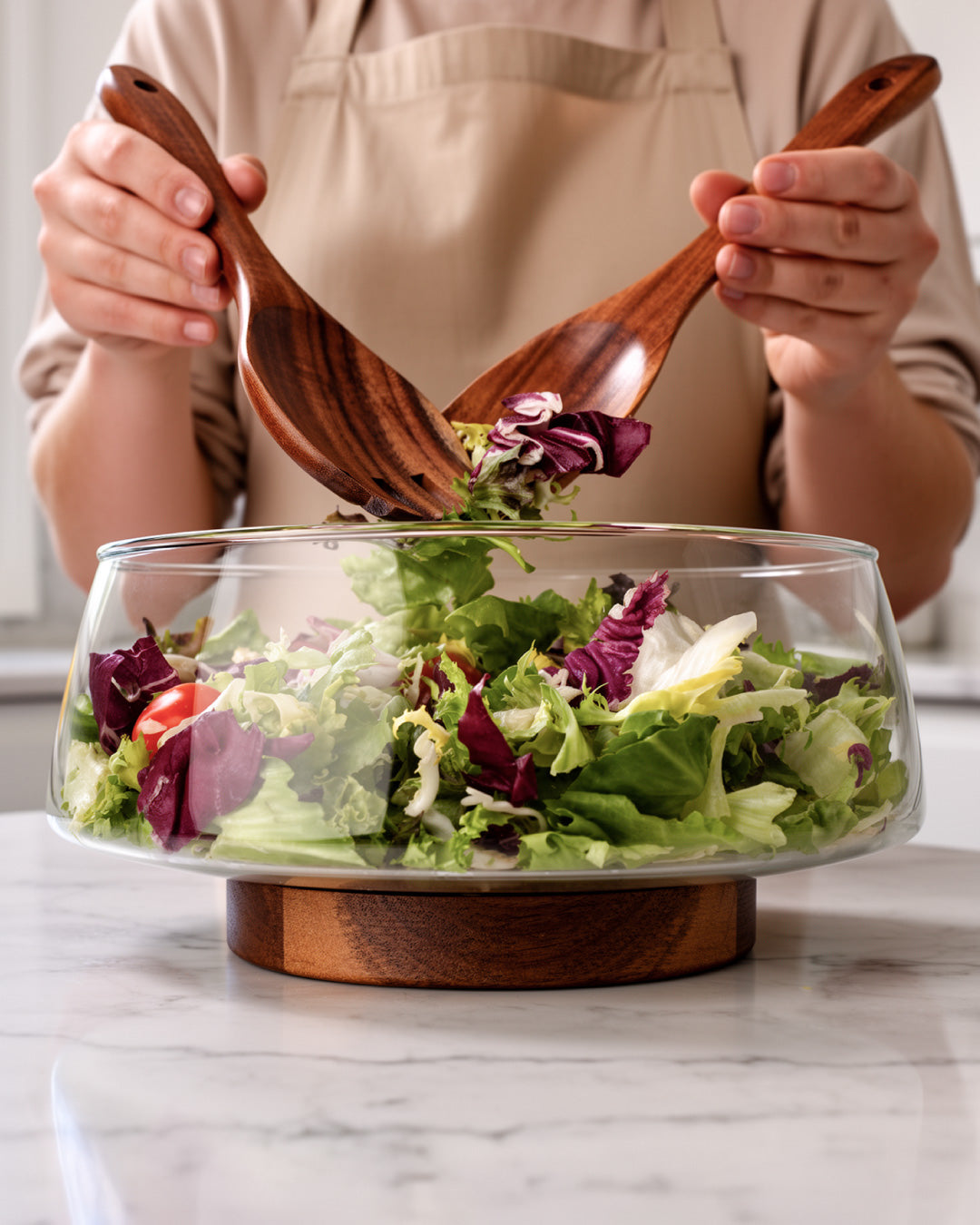 Ciotola per insalata in vetro con posate da insalata e sottopentola